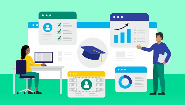 One person sitting at a desk looking at a computer, while another person stands pointing at a chart on a screen.